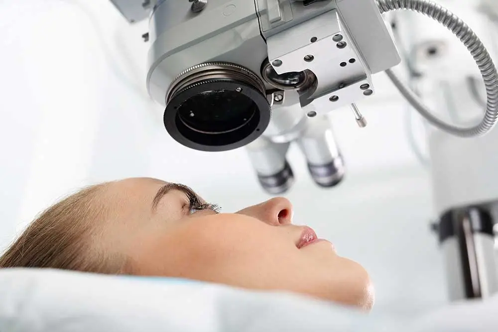 Eye doctor examining an older patient with a slit lamp