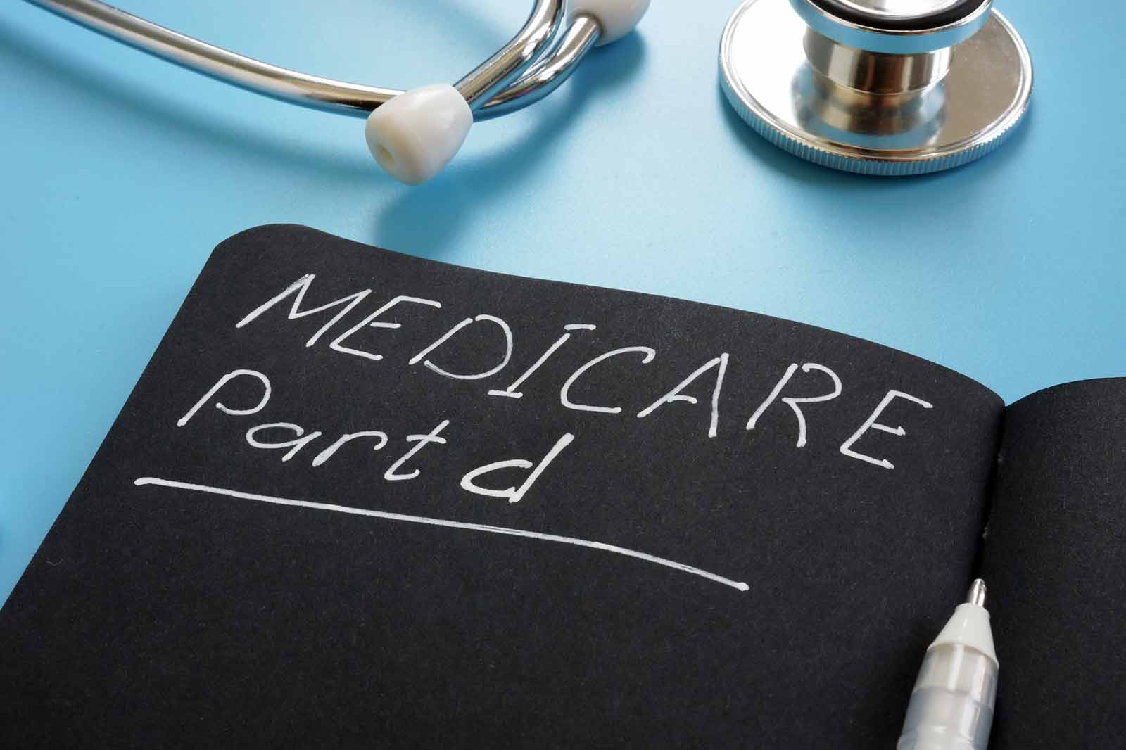 Notebook with "Medicare Part D" handwritten in chalk next to a stethoscope